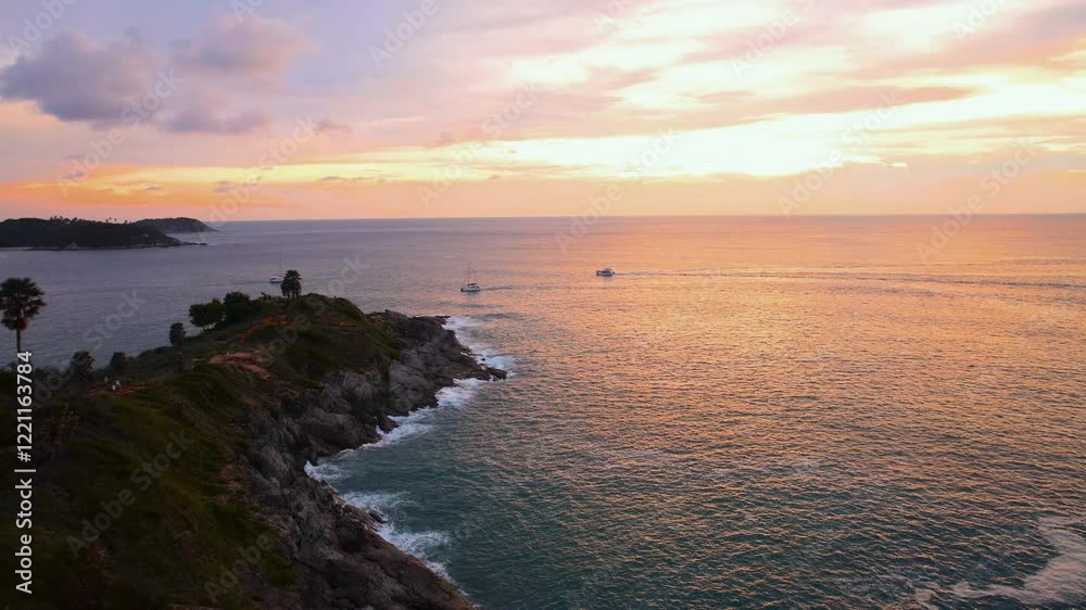 Promthep cape sunset in phuket, thailand, with boats sailing on calm sea Promthep cape sunset in phuket, thailand, with boats sailing on calm sea