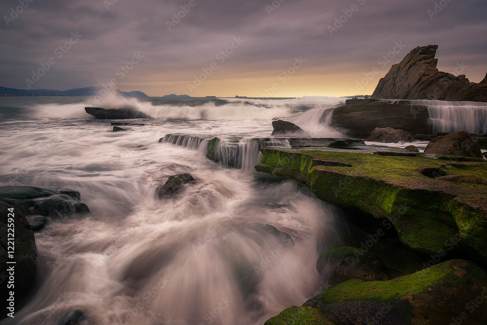 Obraz premium The waves enter with force between the rocks of the coast of the Cantabrian Sea on Azkorri beach in Getxo, Bizkaia