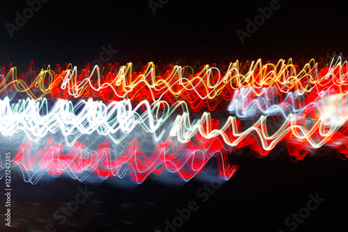 Abstract blurred colorful light effect on a black background. Long exposure photo of moving camera.
