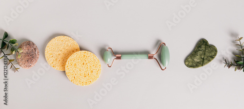 Jade massagers gua sha and roller and sponges for face top view web banner photo