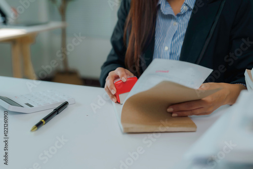 Businesswoman stamping document at office desk