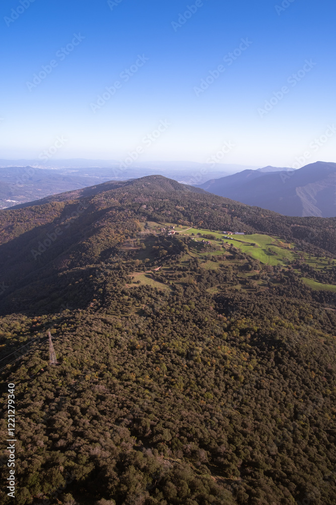 Obraz premium Beautiful scenic view from the top of a mountain seeing the beautiful skyline of green mountains in Girona, Catalonia