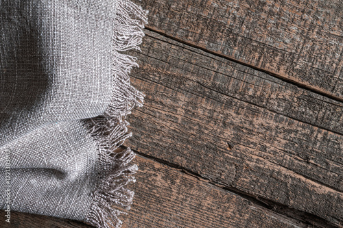 Linen woven napkin lies on an old wooden table