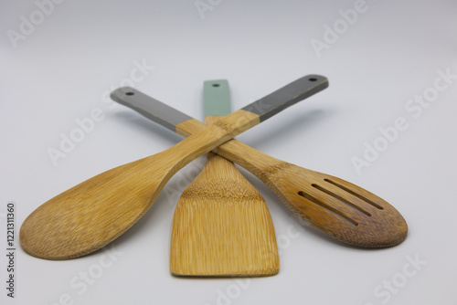 View of three kitchen spoons on a light background.