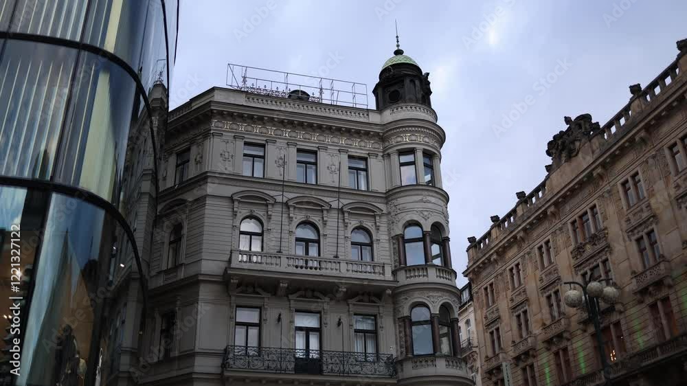 An elegant historic building in Prague, featuring ornate balconies, arched windows, and a distinctive corner tower with a green dome. The architecture showcases the city's rich cultural and architectu An elegant historic building in Prague, featuring ornate balconies, arched windows, and a distinctive corner tower with a green dome. The architecture showcases the city's rich cultural and architectu