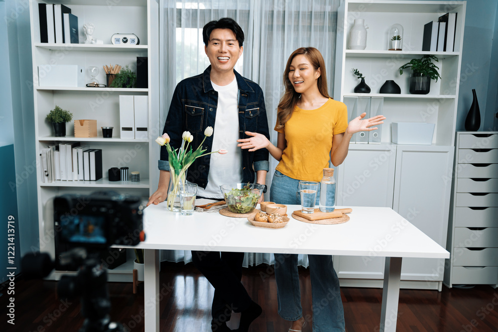 Cooking show on live streaming with two chef influencers teaching mixed salad with dressing for easy special recording on video camera. Ingredients placing bread bun wholegrain side dish. Infobahn. Cooking show on live streaming with two chef influencers teaching mixed salad with dressing for easy special recording on video camera. Ingredients placing bread bun wholegrain side dish. Infobahn.