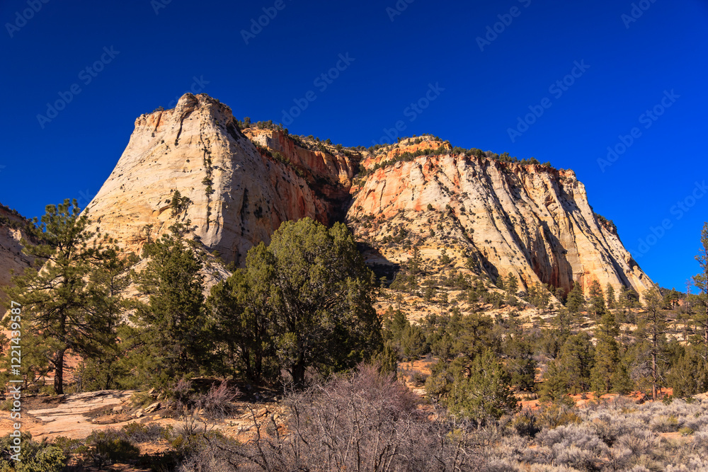 Fototapeta premium A mountain range with a blue sky in the background