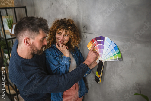 Tableau sur toile concentrated couple stand in front grey wall and hold color swathes