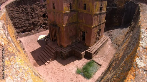 Tilting handheld view of famous monolithic rock-hewn Church of Saint George in Lalibela, religion and history in Ethiopia 

