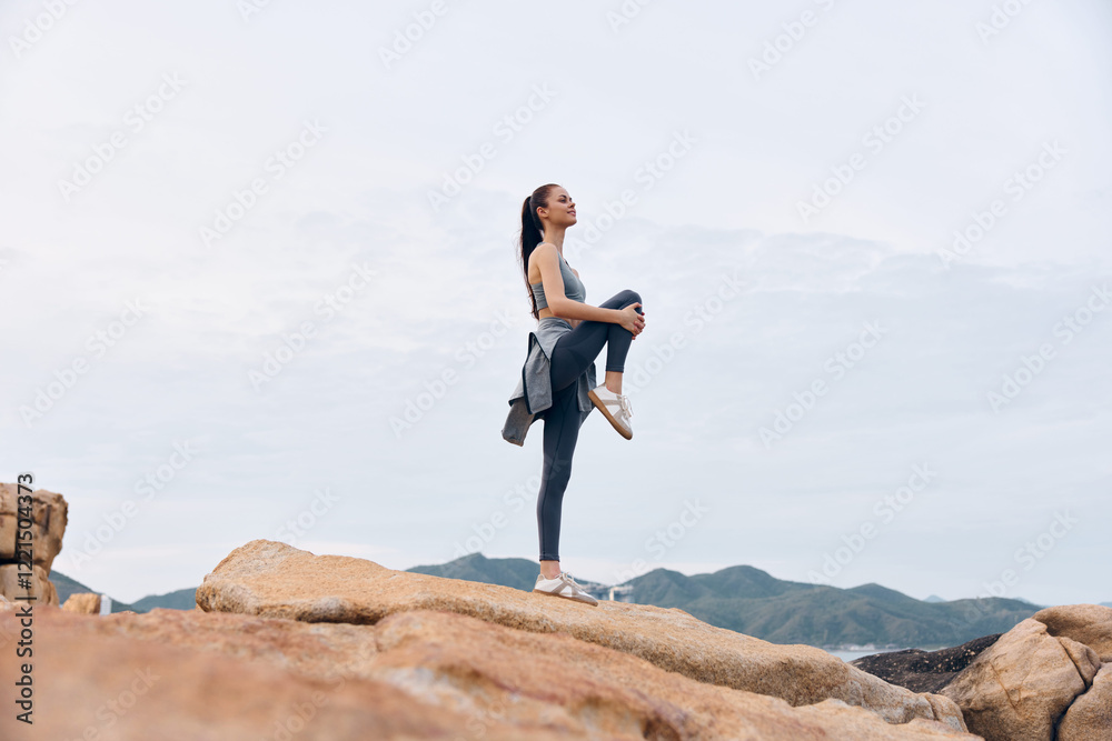 Young woman practicing yoga on a rocky beach, balancing her body in a serene pose, surrounded by nature s beauty and soft colors of dawn or dusk Young woman practicing yoga on a rocky beach, balancing her body in a serene pose, surrounded by nature s beauty and soft colors of dawn or dusk