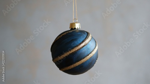 The reflective disco ball shaped like a Christmas ornament hangs gracefully with a sparkling golden stripe. It adds a festive touch and creates a vibrant atmosphere for holiday celebrations photo