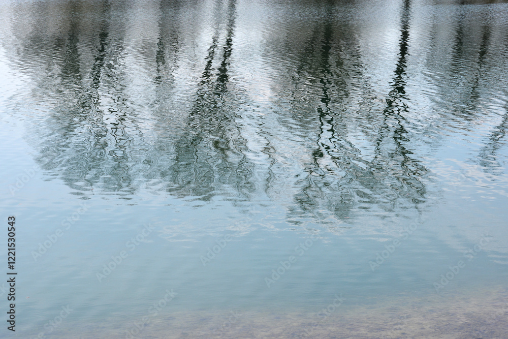Blurry reflections of trees in calm water, creating an abstract and serene scene Blurry reflections of trees in calm water, creating an abstract and serene scene
