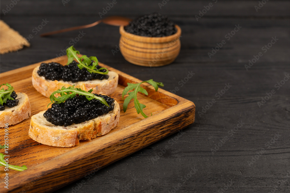 Bread slice with black caviar served on on wooden table Bread slice with black caviar served on on wooden table