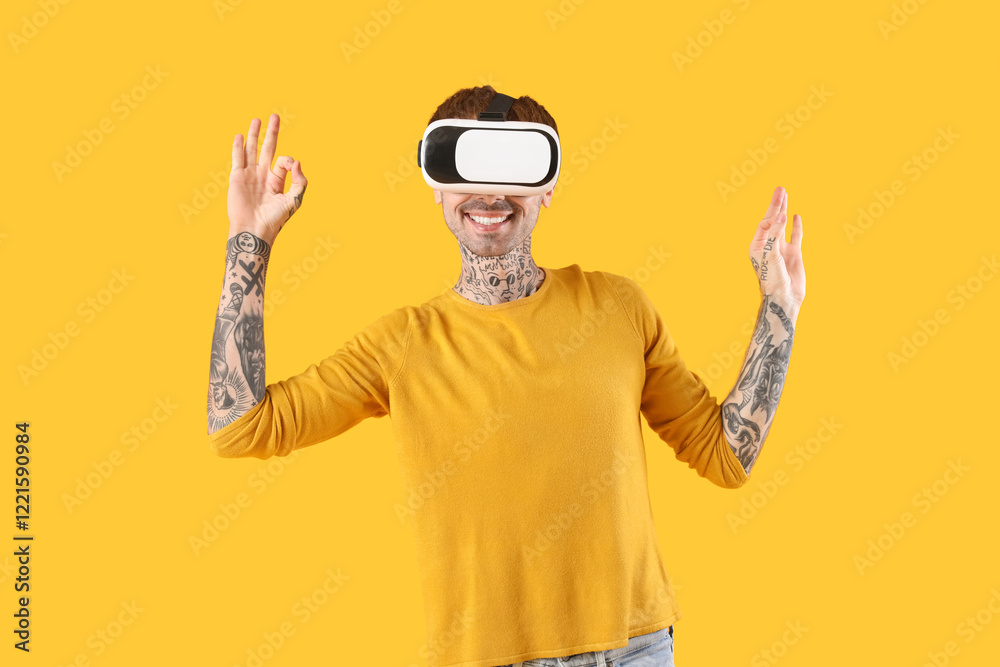 Naklejka premium Happy young man in VR headset on yellow background