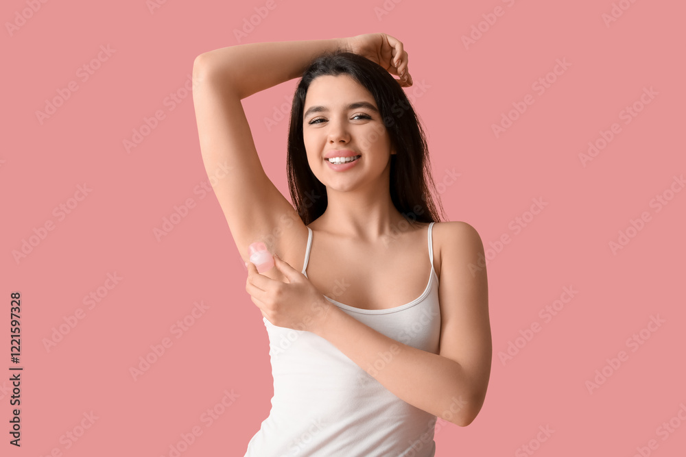 Happy smiling young woman using crystal deodorant on pink background Happy smiling young woman using crystal deodorant on pink background
