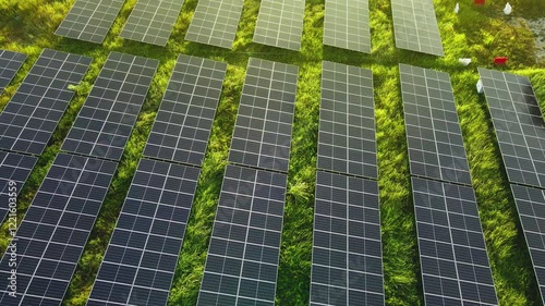 Aerial 4K view of solar panels installed on a landscaped field, showcasing clean and sustainable energy solutions.