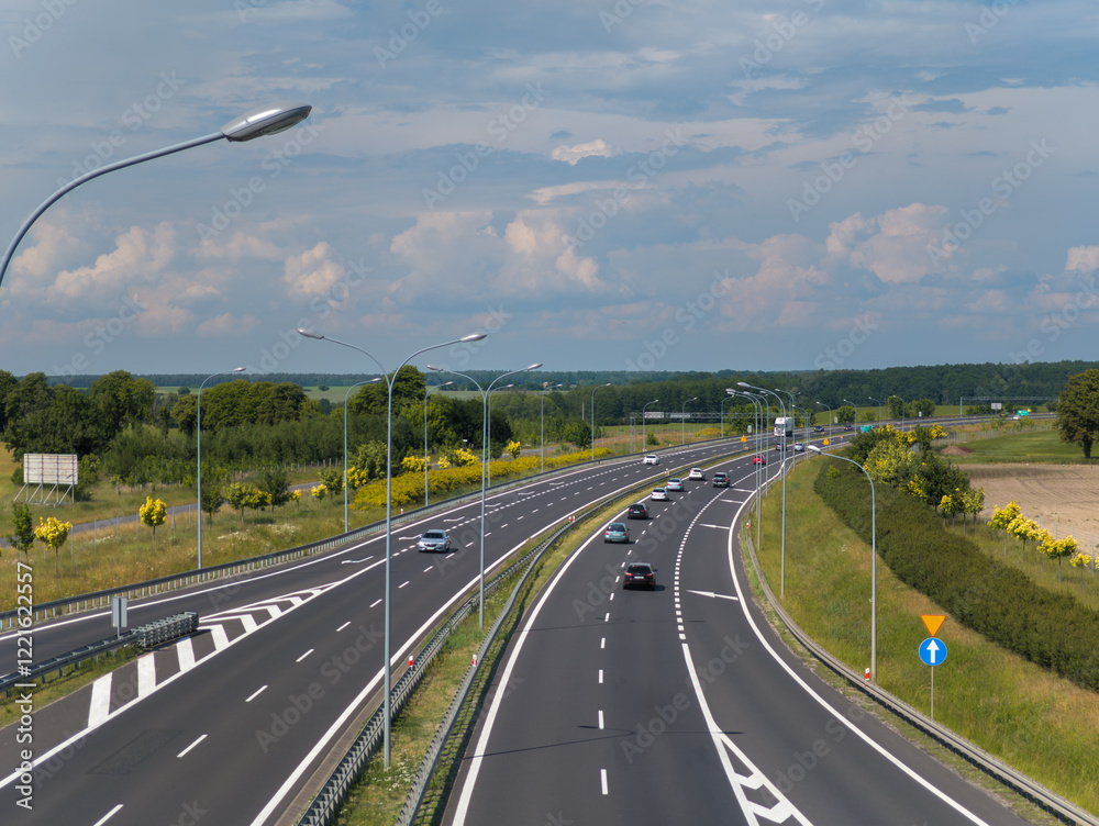 Summer landscape view of cars moving on the freeway (highway) road between Poznan and Bydgoszcz (Droga ekspresowa S5) in Wielkopolska, Poland