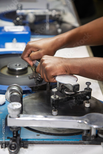 Polishing wheel in a diamond factory in Botswana, showcasing an African worker's hands polishing a rough diamond facet on a spinning wheel, representing precision and craftsmanship, diamond industry