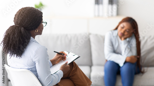 Fotografie Depressed black lady receiving professional psychological help at mental clinic, selective focus