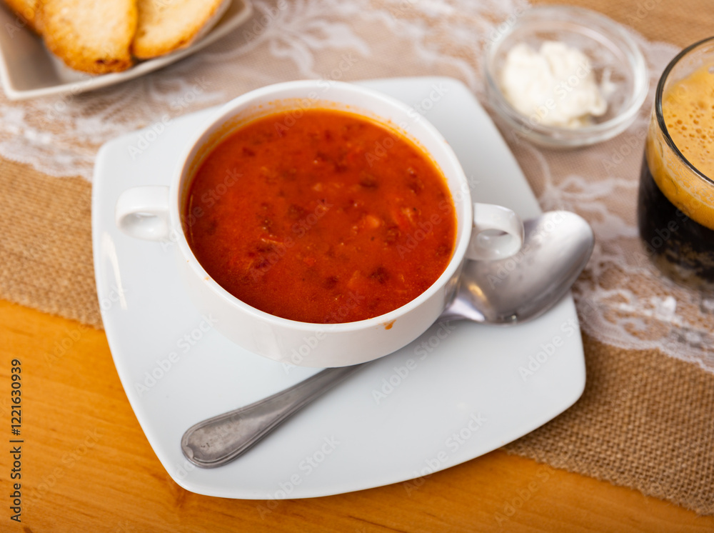 Borsch, beetroot hot soup and bread on the table in a cafe Borsch, beetroot hot soup and bread on the table in a cafe