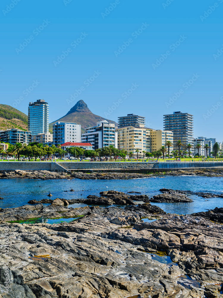 Vertical shot of Sea Point view from the ocean with rocks and sparkling Atlantic Ocean, Cape Town, South Africa
