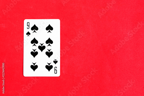 Nine of Spades playing card on red background, top view, copy space photo