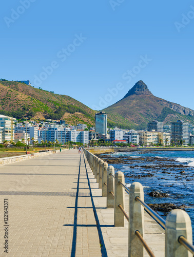 Obraz na płótnie Vertical shot of vibrant Sea Point Promenade and sparkling Atlantic Ocean with iconic Lion's Head Mountain in the background, Cape Town, South Africa w salonie
