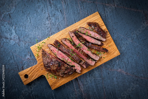 Barbecue grilled dry aged meat wagyu beef flank steak cut as tagliata on wooden board with text space