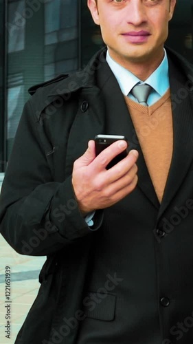 Slow motion: Young white successful businessman, manager recive positive sms, in front of modern building. Leader. Teal and orange. Middle shot Vertical Shot. photo