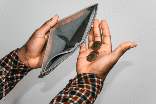 Black hands Holding empty opened men wallet With few Ghanaian cedi coins in palm. no money poor broke person concept