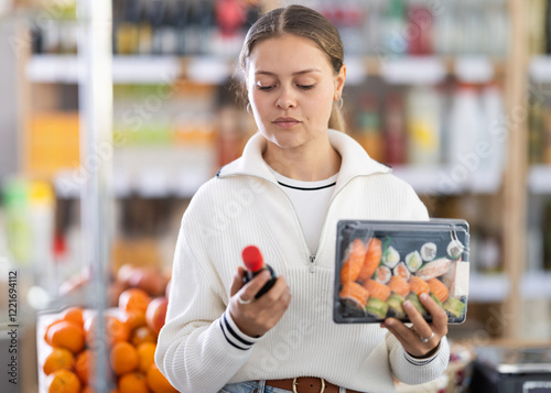 European woman chooses soy sauce for sushi. High quality photo photo