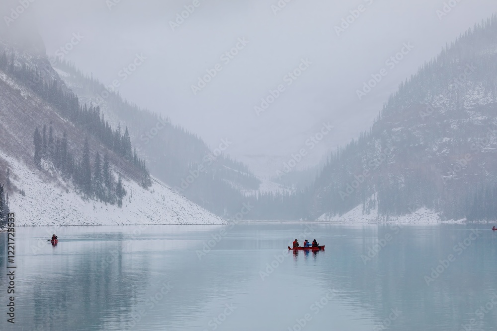 Snowy, misty day on Lake Louise,. Kayakers navigate the calm waters. Banff National Park, Alberta, Canada Snowy, misty day on Lake Louise,. Kayakers navigate the calm waters. Banff National Park, Alberta, Canada