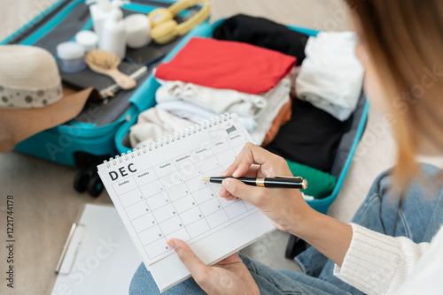 Holiday calendar for travel, Traveler, travel bag. choose country for travel. Asian Young women are prepare clothes and personal belongings. Pack your luggage before travel, Travel, life style photo