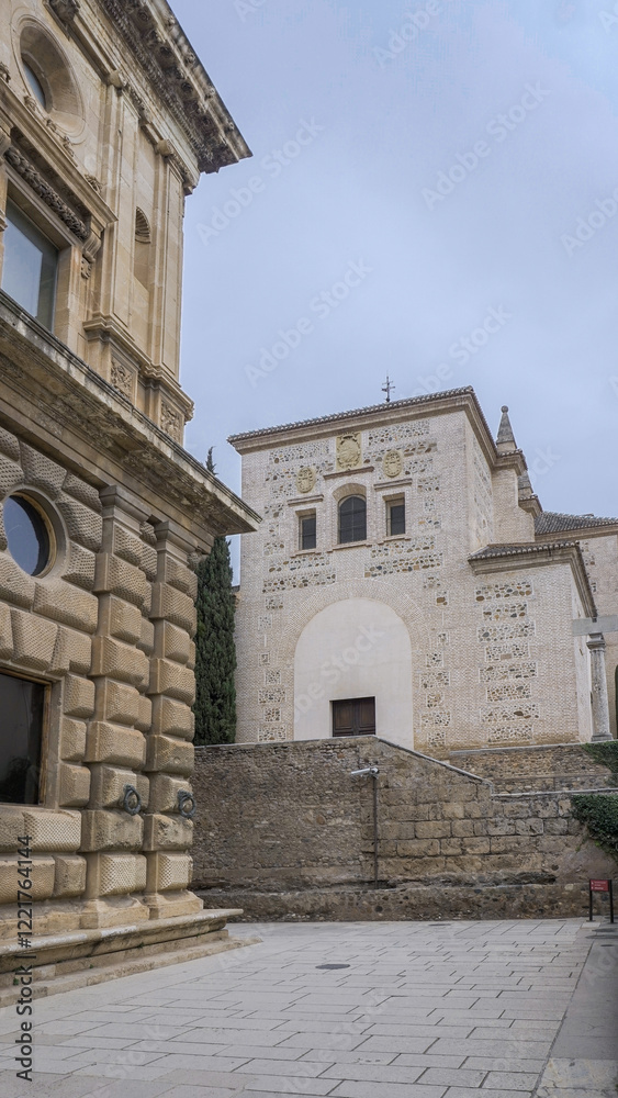 Fototapeta premium A narrow, cobbled street lined with ancient stone buildings. The imposing facade of a historic church dominates the scene, its intricate carvings and weathered stone contrasting with the simpler, more