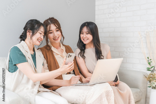 家で一緒にスマホとノートパソコンを使う女性・友達・ママ友・仲間
