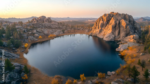 Serene Sunset Over Mountain Lake with Rocky Outcrops and Trees