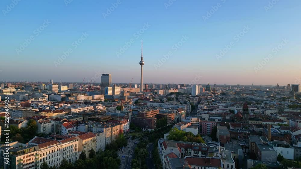 Berlin tv tower rising above rooftops and a construction site at senefelderplatz during sunset. Dramatic aerial view flight descending drone Berlin tv tower rising above rooftops and a construction site at senefelderplatz during sunset. Dramatic aerial view flight descending drone