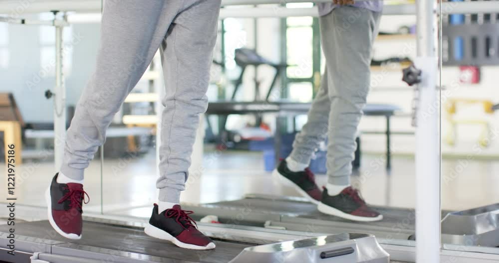 Man in rehabilitation center walking using parallel bars for physical therapy