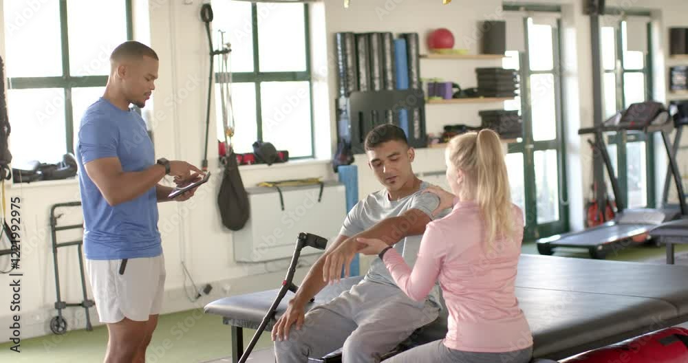 Assisting man with arm exercises, therapist in rehabilitation session, trainer observing