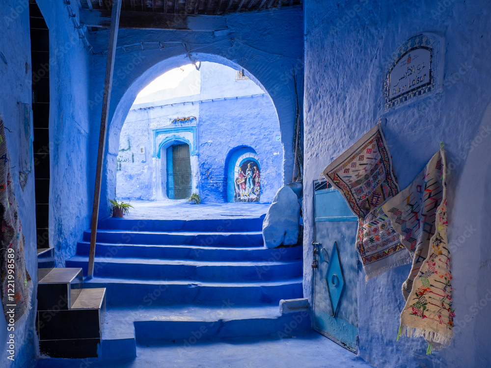 Naklejka premium Chefchaouen, the blue city in Morocco - doorways through an arch with steps