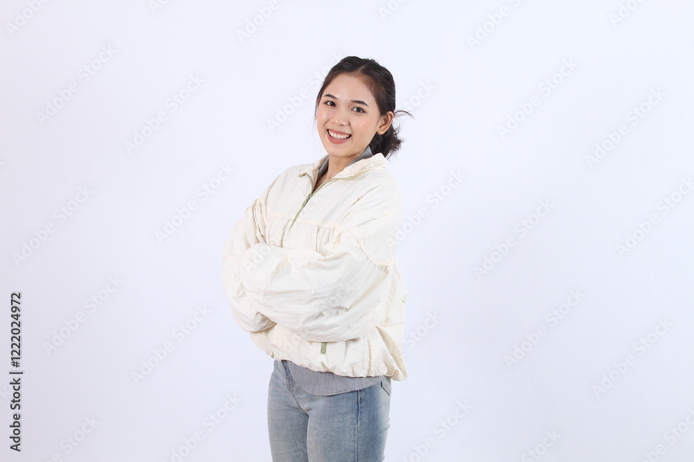 Young Adult Poses Confidently with Folded Arms on White Background, Casual Fashion Inspiration Young Adult Poses Confidently with Folded Arms on White Background, Casual Fashion Inspiration