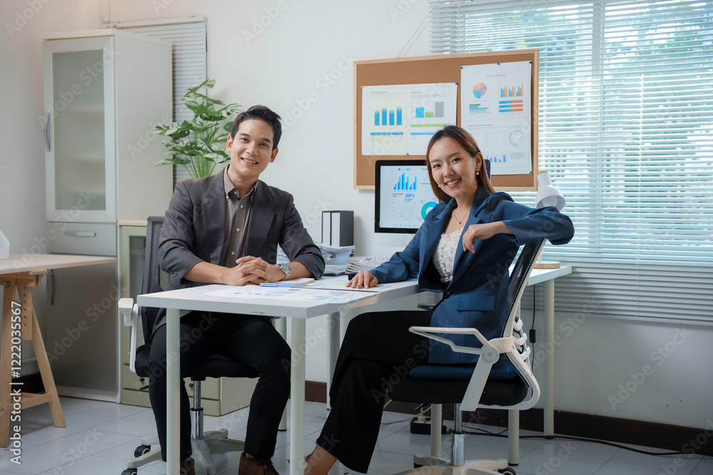 Asian businesspeople smiling while working in modern office Asian businesspeople smiling while working in modern office