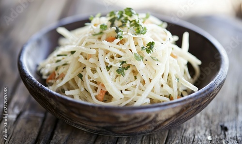Freshly made celeriac salad with herbs in wooden bowl on rustic table