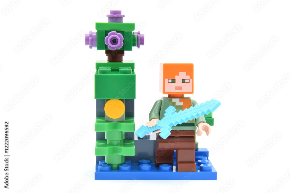 Obraz premium Lego minifigure of Alex from popular game Minecraft with pixel sword isolated on white. Editorial illustrative image of popular plastic toys.