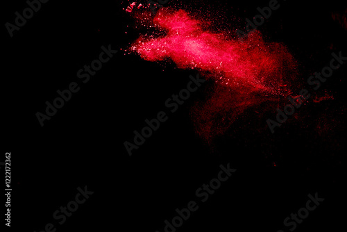 Red dust particles explosioon on black background.Red powder splash.