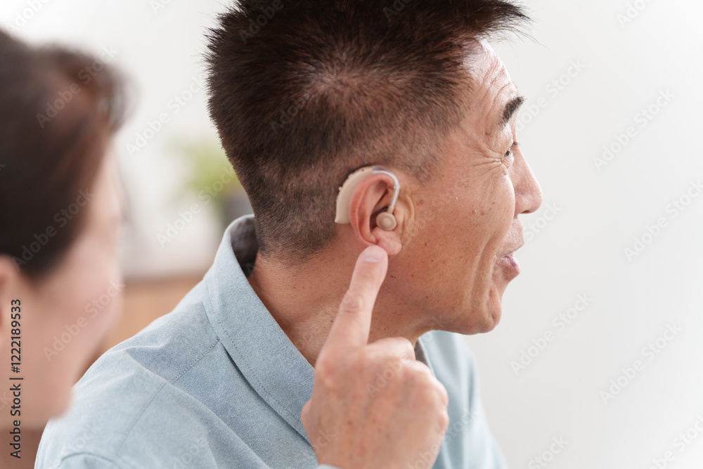 補聴器をつけて会話するシニア男性 補聴器をつけて会話するシニア男性