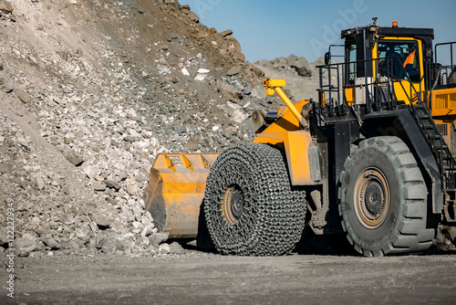 Heavy industrial wheel loader at mining site, temporary storage of ore for loading and transportation to mine and processing plant. photo