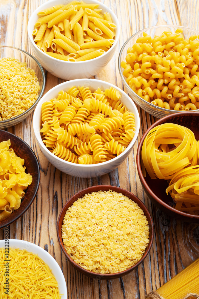 Assorted Uncooked Pasta in Bowls on Wooden Table Assorted Uncooked Pasta in Bowls on Wooden Table