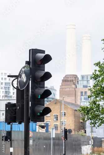 This image showcases traffic lights in the foreground with a historically significant power station rising prominently in the background, symbolizing progress and history in London UK photo