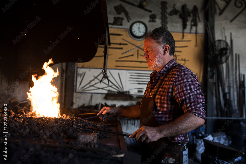 Blacksmith working at forge in his workshop